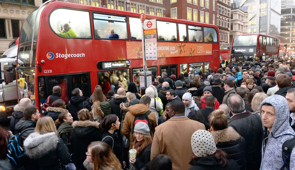 Orang-orang berdesakan memasuki bus kota setelah para pekerja kereta api bawah tanah melakukan aksi mogok di London, Senin (9/1). Akibat pemogokan itu, jutaan warga harus menggunakan bus yang penuh sesak atau kereta api biasa. (John Stillwell/PA via AP)