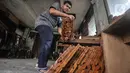 Pekerja menyelesaikan pembuatan rehal atau meja untuk Al-qur’an di Toko Mabruri 12, Klender, Jakarta, Rabu (13/4/2022). Harga rehal di toko ini dibanderol mulai dari Rp50.000 hingga Rp300 ribu per buah, tergantung ukuran dan jenis kayu. (merdeka.com/Iqbal S Nugroho)