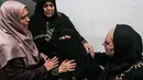 Kerabat korban paramedis Palestina, Abdullah al-Qutati yang meninggal ditembak tentara Israel menghibur ibu korban selama pemakaman putranya di Rafah, Jalur Gaza, Sabtu (11/8). (SAID KHATIB/AFP)