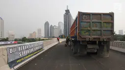 Sebuah truk dipersiapkan saat uji beban statis dan dinamis Simpang Susun Semanggi, Jakarta, Kamis (13/7). Uji beban tersebut dilakukan guna menguji kelayakan Simpang Susun Semanggi sebelum diresmikan pada 17 Agustus mendatang. (Liputan6.com/Angga Yuniar)