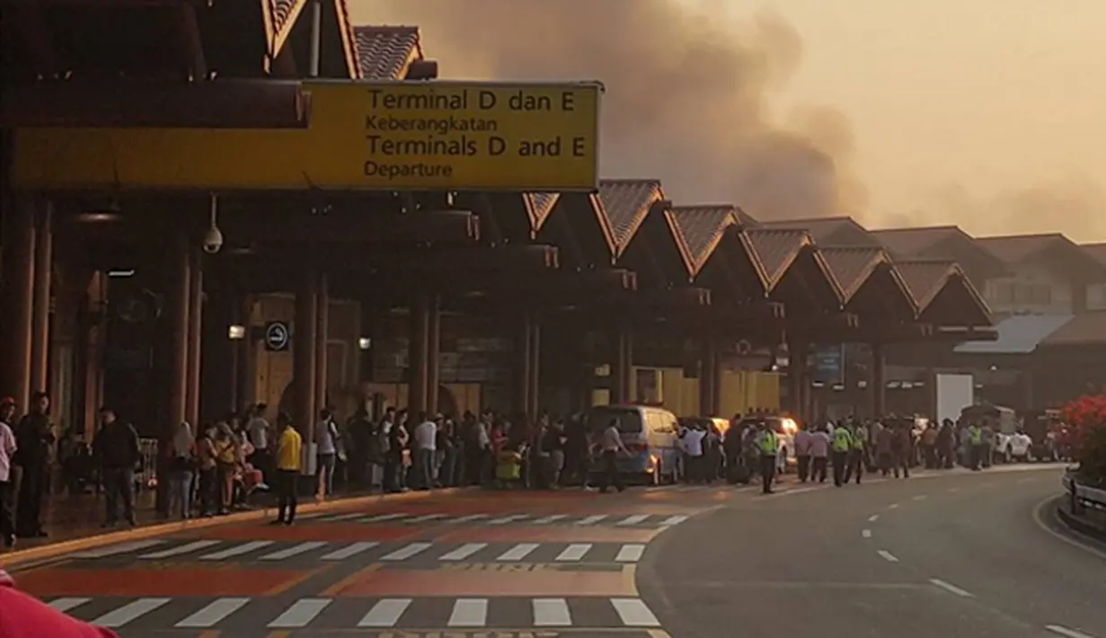 Sejumlah penumpang melihat kebakaran yang terjadi di Terminal 2E di Bandara Soekarno Hatta, Jakarta, Minggu (5/7/2015).  Kebakaran di Terminal 2E ini membuat panik ribuan penumpang yang sedang menunggu jadwal penerbangan. (Twitter@avgustin88)