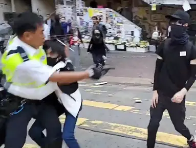 Polisi (kiri) menembak seorang demonstran prodemokrasi (kanan) saat terjadi protes di Distrik Sai Wan Ho, Hong Kong, Senin (11/11/2019). Aksi penembakan yang dilakukan polisi tersebut tersiar secara langsung lewat layanan streaming Facebook. (LAURENT FIEVET/CUPID NEWS/AFP)