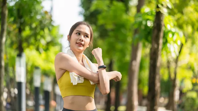Seorang perempuan sedang melakukan pemanasan sebelum berolahraga (Foto Dok: Freepik/Lifestylememory)