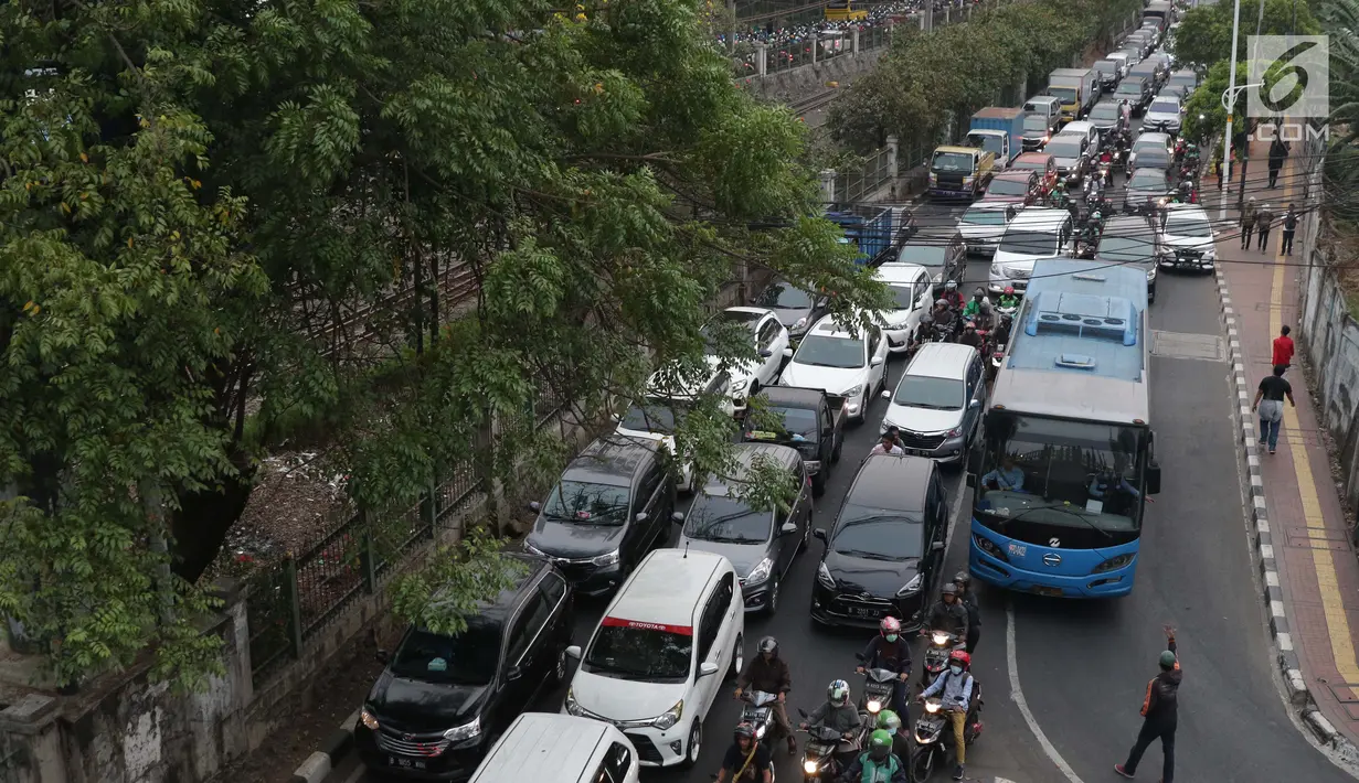 Pak Ogah mengatur arus lalu lintas yang mengalami kemacetan di sekitar kawasan Pejompongan akibat unjuk rasa mahasiswa di depan Gedung DPR, Jakarta, Selasa (24/9/2019). Demonstrasi mahasiswa dilakukan untuk menolak pengesahan berbagai RUU yang dianggap bermasalah. (Liputan6.com/Helmi Fithriansyah)