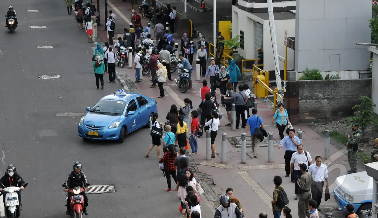 Pekerja berjalan kaki saat pulang kantor di Jalan Sudirman menuju Bendungan Hilir, Jakarta, Rabu, (22/4/2015). Tak adanya bus yang melintas karena adanya pengalihan arus untuk KAA membuat mereka terpaksa jalan kaki. (Liputan6.com/Johan Tallo)