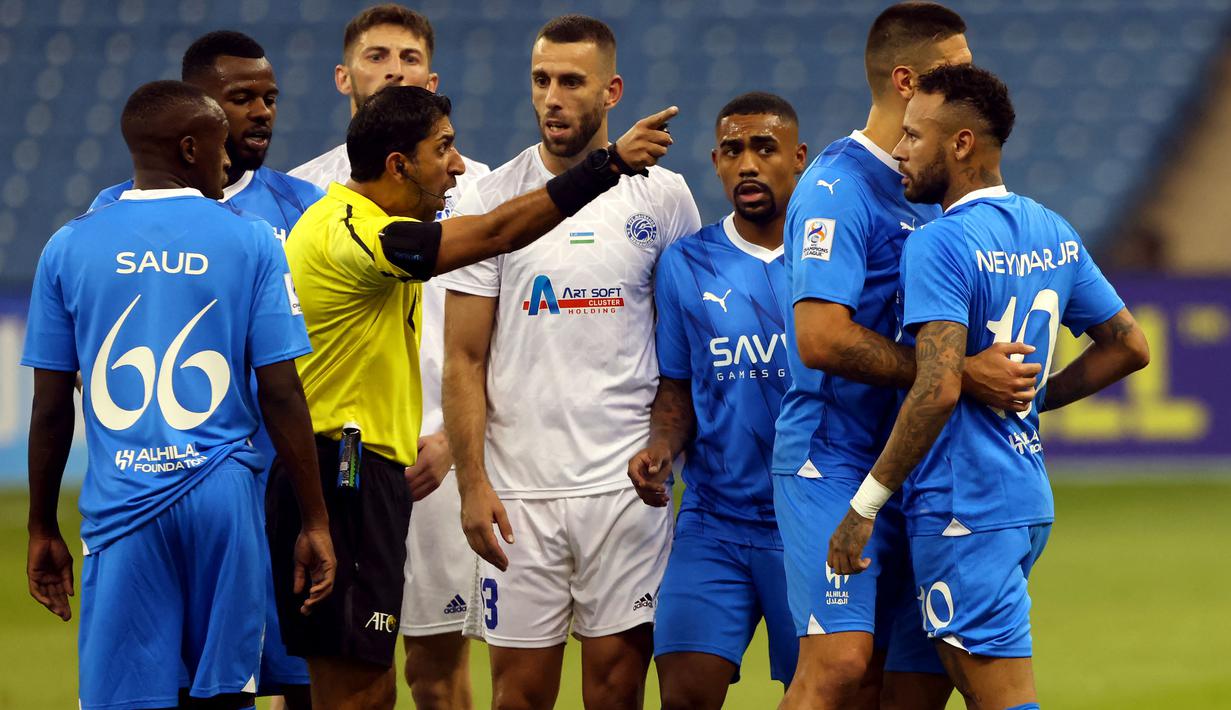 Striker Al Hilal, Neymar (kanan) memprotes keputusan wasit yang memberinya kartu kuning saat menghadapi PFC Navbahor pada laga Grup D Liga Champions Asia 2023/2024 di King Fahd International Stadium, Riyadh, Selasa (19/9/2023) dini hari WIB. (AFP/Fayez Nureldine)