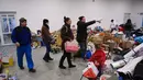 Orang-orang membawa sumbangan ke pusat pengungsian sementara di sekolah dasar setempat di Tiszabecs, Hongaria timur, 28 Februari 2022. Warga Hungaria bergegas ke perbatasan Ukraina untuk membantu pengungsi yang melarikan diri dari invasi Rusia. (Attila KISBENEDEK/AFP)