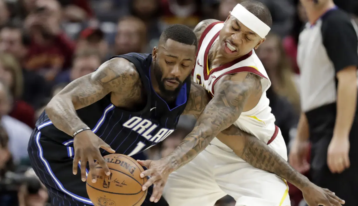 Pemain Cleveland Cavaliers, Isaiah Thomas (kanan) berusaha menghalau bola dari genggaman pemain Orlando Magic, Jonathon Simmons pada lanjutan NBA basketball game di Quicken Loans Arena, (18/1/2018). Cavaliers menang 104-103. (AP/Tony Dejak)