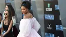 Rihanna berpose untuk fotografer pada pemutaran perdana "Valerian and The City of a Thousand Planets" di Los Angeles, 17 Juli 2017. Rihanna mengenakan gaun off-shoulder dengan siluet mini dress berwarna merah muda yang manis. (Jordan Strauss/Invision/AP)
