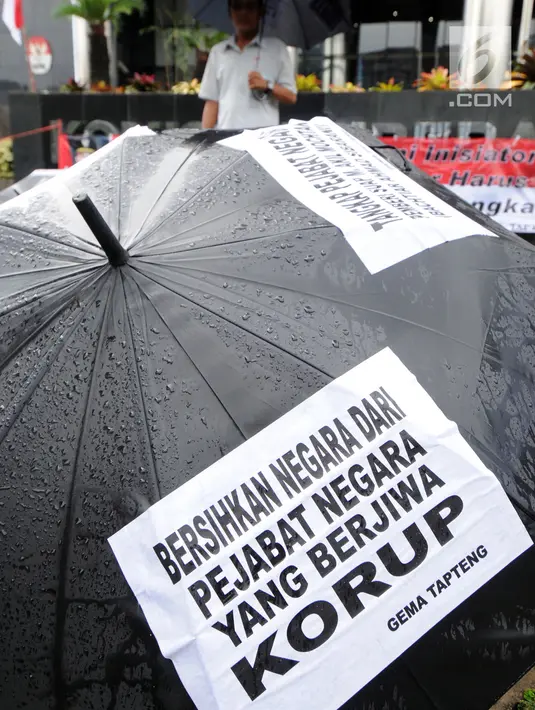 Sejumlah payung hitam dipampang oleh aktivis Gema Tapteng saat melakukan aksi unjuk rasa di depan gedung KPK, Jakarta, Kamis (26/4). Bakhtiar Ahmad Sibarani dinilai telah memberi suap terhadap mantan  Ketua MK, M Akil Mochtar. (Merdeka.com/Dwi Narwoko)
