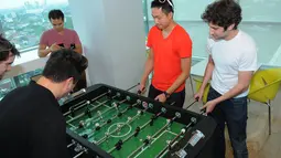 Justin Khan (Justin.tv), Daniel Kan (Exec), Tikhon Bernstam (Scribd & Parse), Ammon Bartram (SocialCam) dan Kevin Hale (Y Combinator) saat bermain foosball di Liputan6.com, Selasa (06/5/14). (Liputan6.com/Fasial R Syam)