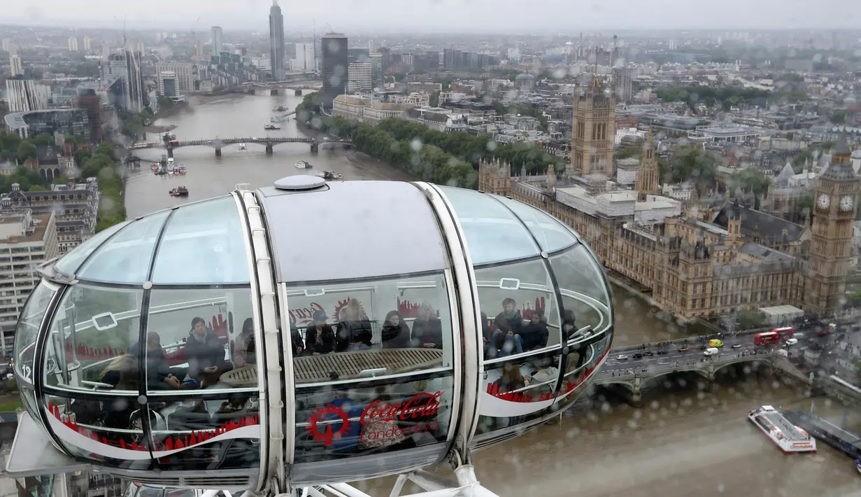 Pemandangan saat sejumlah peserta mengikuti kelas meditasi di dalam kapsul London Eye dengan latar belakang kota London dan Sungai Thames di London, Inggris (15/5). (AP Photo / Alastair Grant)