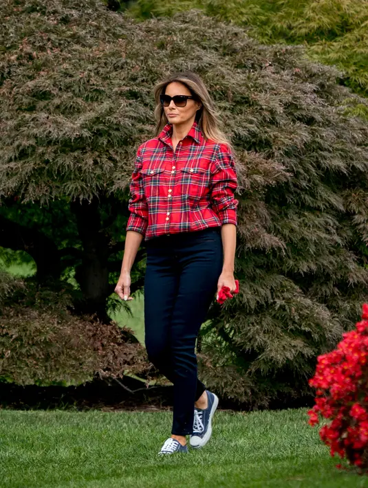 Ibu Negara AS, Melania Trump bersiap berkebun bersama anak-anak di Kitchen Garden Gedung Putih, Jumat (22/9). Memakai kemeja tartan keluaran Balmain seharga Rp 18 juta, penampilan Melania dianggap terlalu mewah untuk berkebun. (AP Photo/Andrew Harnik)