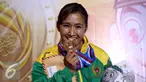 Karateka Jawa Timur, Sisilia Agustiani menggigit medali emas usai memenangi laga final Kata Putri PON XIX di GOR Sabuga, Bandung, Minggu (18/9). Di final, Sisilia berhasil mengungguli karateka Jawa Barat, Yulianti. (Liputan6.com/Helmi Fithriansyah)