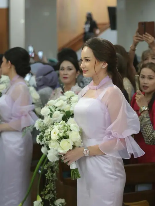 Pada acara pemberkatan nikah tersebut, tampak beberapa teman selebriti hadir untuk menjadi saksi. Enzy yang membawa bunga yang menjadi bridesmaid tampak beberapa kali mengusap air mata menyaksikan sahabatnya menikah. [Foto: Daniel Kampua/Fimela.com]