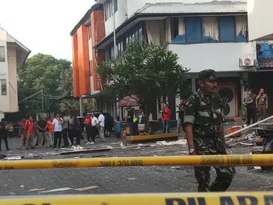 Seorang petugas berjaga dekat garis polisi yang terpasang di lokasi ledakan di kawasan Ruko Grand Wijaya, Kebayoran Baru, Jakarta Selatan, Kamis (12/7). Polisi memastikan ledakan bukan berasal dari bahan peledak atau bom. (Liputan6.com/Ady Anugrahadi)