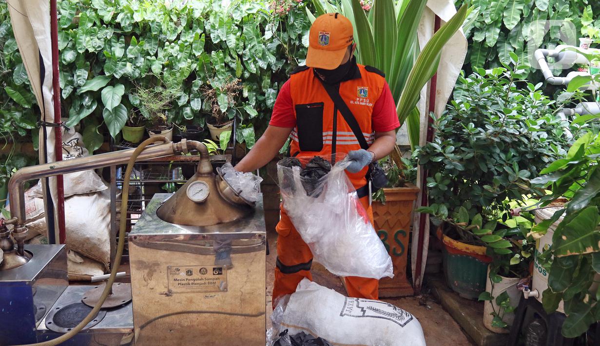 Petugas PPSU Kelurahan Kota Bambu Selatan memasukkan sampah plastik ke dalam mesin di Bank Sampah Hasil Berkah, Jakarta, Kamis (11/11/2021). Sampah plastik dikonversi menjadi solar menggunakan alat mesin pirolisis untuk mengurangi pencemaran lingkungan. (Liputan6.com/Herman Zakharia)