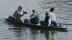 Seorang perempuan mendayung perahu selama jam sekolah di Danau Dal di Srinagar, India, Rabu (11/5/2022). Danau terbesar di negara bagian tersebut penting untuk kegiatan perikanan, perairan, rekreasi, dan pariwisata. (TAUSEEF MUSTAFA / AFP)