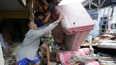 Warga lokal Alimin membersihkan puing-puing dari rumahnya setelah tsunami di Carita, Banten, Kamis, (27/12). Pemerintah telah memperluas zona larangan di sekitar pulau gunung berapi pulau yang memicu tsunami. (AP Photo/Achmad Ibrahim)