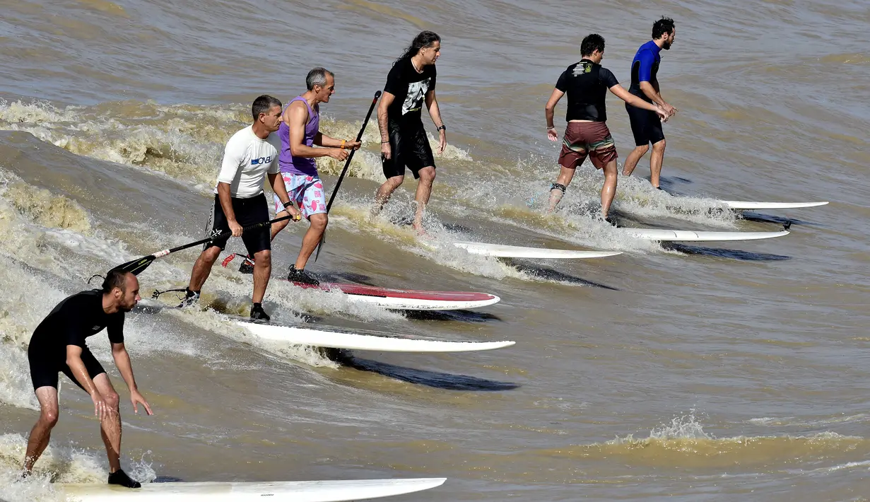 Sejumlah warga saat menikmati bermain surfing di Sungai Dordogne, Saint-Pardon, Prancis (24/7). Fenomena pasang surut besar ini terjadi beberapa kali dalam setahun. (AFP Photo/Georges Gobet)