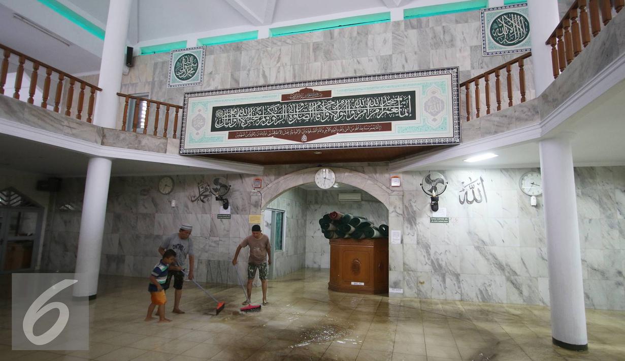 Warga bergotong royong membersihkan banjir yang menggenangi Mesjid An Nur di kawasan Pasar Minggu, Jakarta, Selasa (4/10). Banjir yang rutin menggenangi kawasan tersebut menyebabkan aktivitas warga serta ibadah terganggu. (Liputan6.com/Immanuel Antonius)