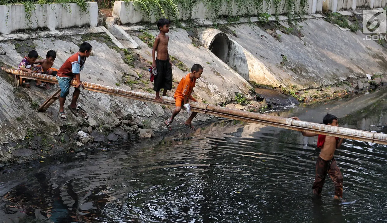 Anak-anak bermain di Kali Gresik di Jalan Muhammad Yamin, Menteng, Jakarta, Rabu (3/7/2019). Minimnya fasilitas bermain gratis, membuat anak-anak tersebut bermain ditempat yang tidak selayaknya. (Liputan6.com/Johan Tallo)