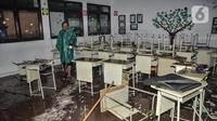 Petugas saat memeriksa kondisi ruang kelas pasca terjangan banjir di Madrasah Tsanawiyah (MTs) Negeri 19 di Jalan Pinang Kalijati, Pondok Labu, Cilandak, Jakarta Selatan, Kamis (6/10/2022). Peristiwa robohnya tembok sekolah bersamaan dengan hujan deras pada sore tadi tersebut diakibatkan oleh terjangan banjir yang menyebabkan tiga siswa tewas dan dua lainnya luka-luka. (merdeka.com/Iqbal S. Nugroho)
