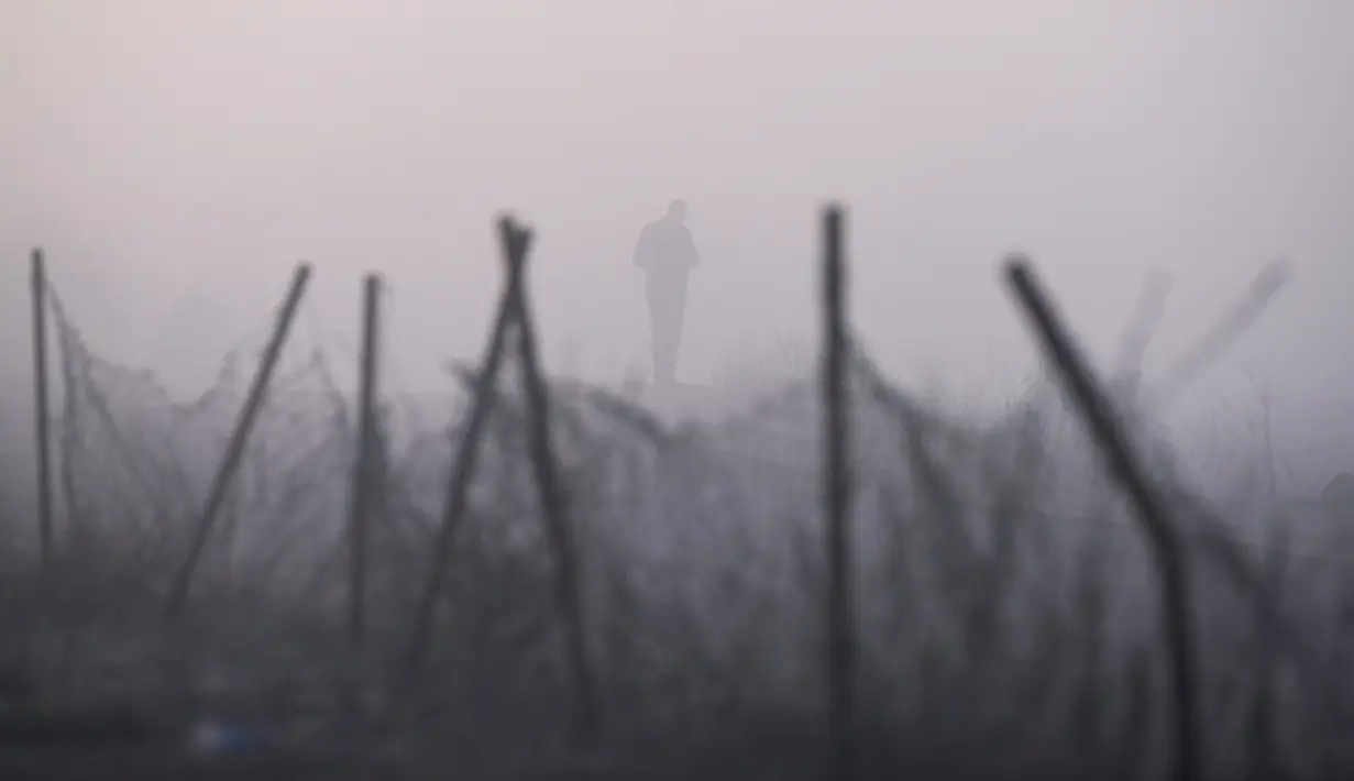 Seorang pria berjalan saat kabut tebal melanda kota Pristina (17/12/2019). Selama beberapa bulan terakhir Pristina terdaftar sebagai salah satu kota yang mengalami kualitas udara terburuk di dunia. (AFP/Armend Nimani)