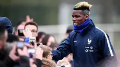 Gelandang timnas Prancis Paul Pogba menyapa penggemar sebelum mengikuti sesi latihan di Clairefontaine-en-Yvelines, Paris (19/3). Pogba bersama timnas Prancis melakukan latihan jelang pertandingan persahabatan. (AFP Photo/Franck Fife)