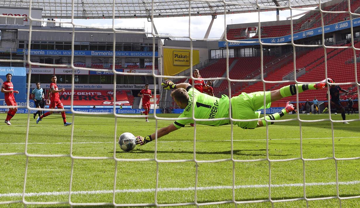 Kiper Bayer Leverkusen, Lukas Hradecky, gagal menghalau bola tendangan pemain Bayern Munchen, Leon Goretzka, pada laga Bundesliga di BayArena, Sabtu (6/6/2020). Bayern Munchen menang 4-2 atas Bayer Leverkusen. (AP/Matthias Hangst)