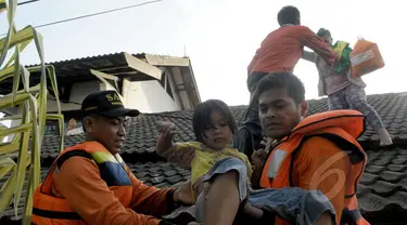 Petugas Basarnas mengevakuasi warga ketika banjir melanda Perumahan Ciledug Indah 1, Tangerang, Selasa (10/2/2015). Banjir merendam ratusan rumah di kawasan tersebut dengan ketinggian mencapai 90 cm. (Liputan6.com/Andrian M Tunay)