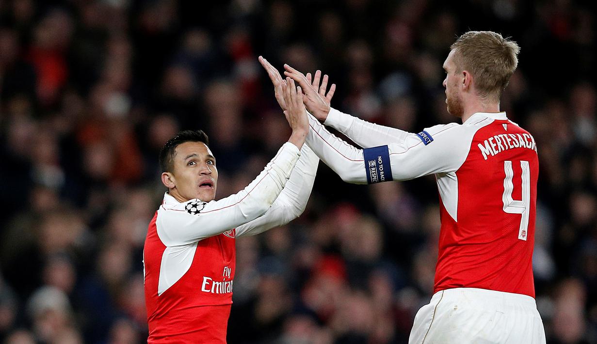 Pemain Arsenal, Alexis Sanchez, merayakan golnya bersama Per Mertesacker dalam laga Grup F Liga Champions di Stadion Emirates, London, Rabu (25/11/2015) dini hari WIB. (AFP Photo/Adrian Dennis)