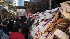 Para pelajar menaruh papan Ema berisi harapan mereka di Kuil Yushima Tenmangu, Tokyo, Jepang, (7/1). Para siswa dan orang tua di Tokyo ramai-ramai mengunjungi Kuil Yushima Tenmangu untuk berdoa sebelum ujian sekolah dimulai. (AFP Photo/Kazuhiro Nogi)