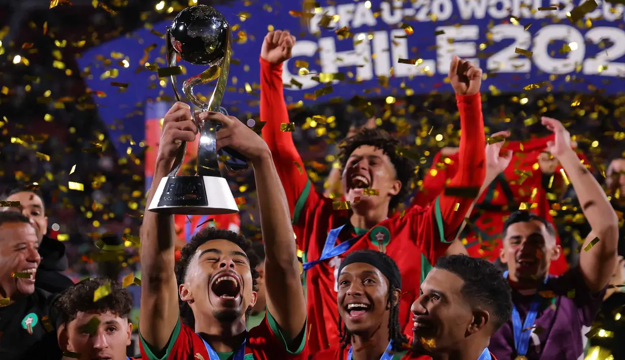 Timnas Maroko merayakan kemenangan dengan trofi setelah memenangkan final Piala Dunia U-20 2025 melawan Argentina di Estadio Nacional Julio Martinez Pradanos, Santiago, pada Minggu 19 Oktober 2025 waktu setempat atau Senin 20 Oktober 2025 pagi WIB. (Javier TORRES/AFP)