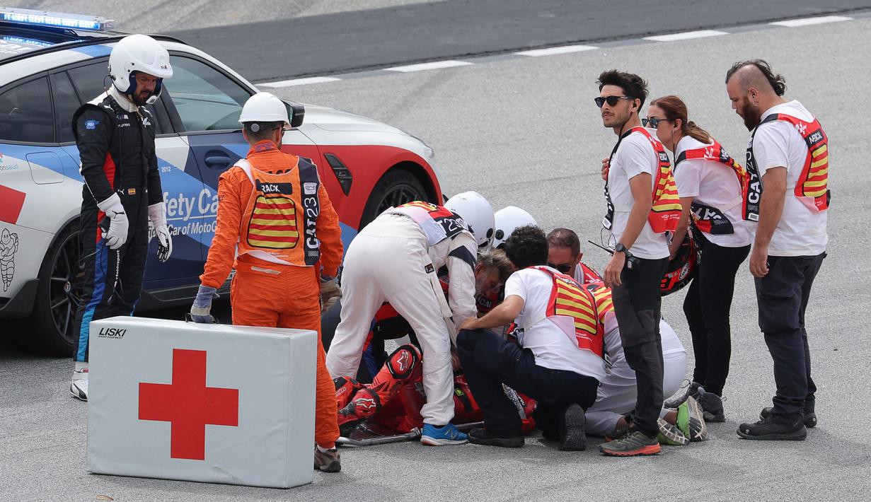 Pecco Bagnaia yang sedang memimpin balapan mengalami highside. Pecco Bagnaia langsung mendapat perawatan di trek dan terlihat dalam kondisi sadar. (AFP/Lluis Gene)