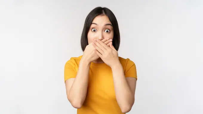 Seorang perempuan menutup mulutnya dengan kedua tangan (Foto Dok: Freepik/benzoix)