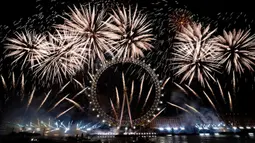 Kembang api menerangi langit di atas London Eye di pusat Kota London untuk merayakan Tahun Baru pada Senin (1/1/2024). (AP Photo/Alberto Pezzali)