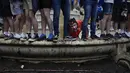 Suporter Skotlandia memanjat patung William Shakespeare di Leicester Square sebelum pertandingan grup D Euro 2020 antara Inggris melawan Skotlandia, di London, Jumat, (18/6/2021). (Foto: AP/Kirsty Wigglesworth)