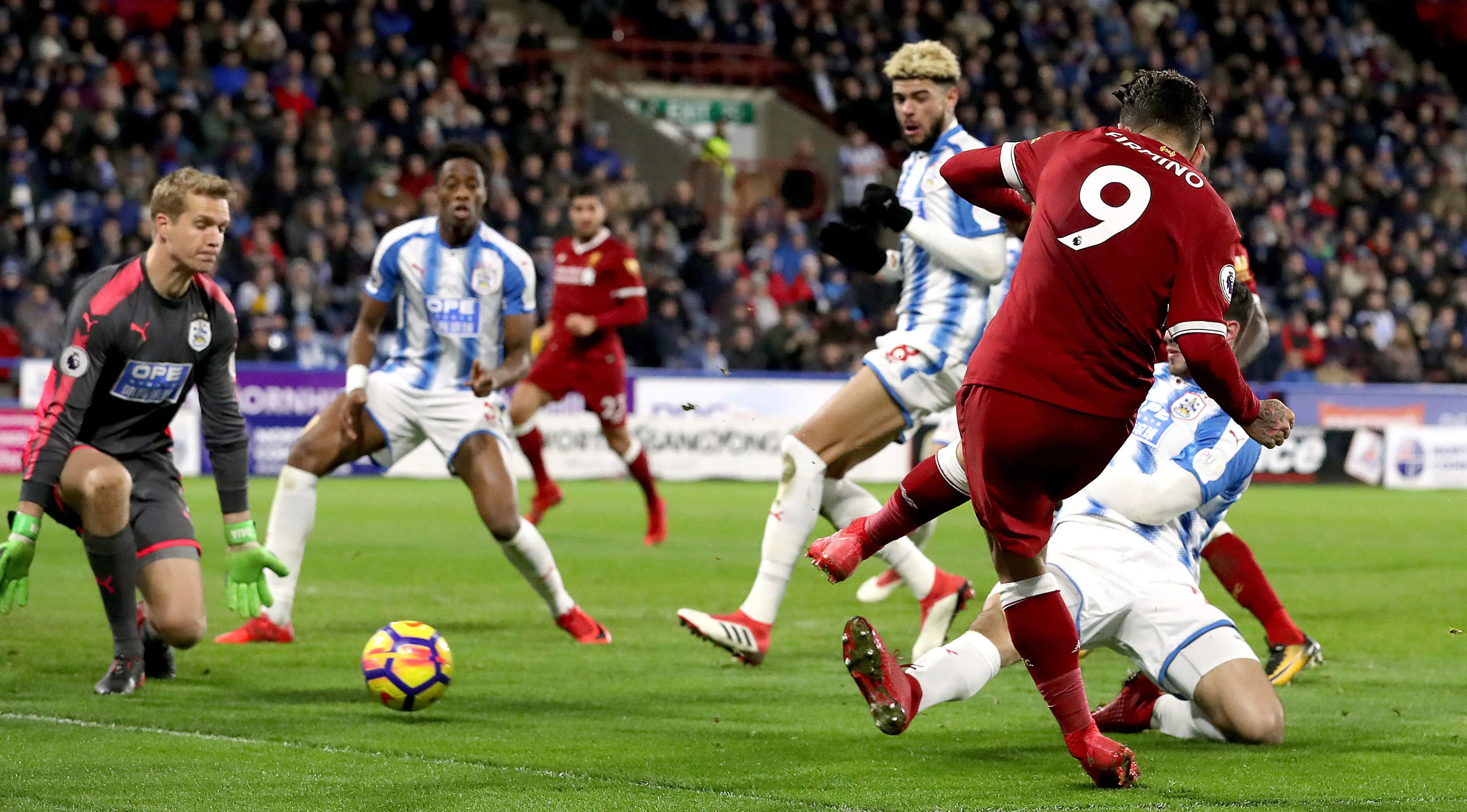 Pemain Liverpool, Roberto Firmino berhasil mencetak gol ke gawang Huddersfield Town pada pertandingan pekan ke-25 Premier League di John Smith's Stadium, Selasa (30/1). Liverpool menang telak tiga gol tanpa balas. (Martin Rickett/PA via AP)
