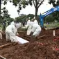 Petugas memakamkan jenazah dengan protokol COVID-19 di TPU Srengseng Sawah, Jakarta, Kamis (21/1/2021). Sebagian lahan TPU Srengseng Sawah yang dijadikan lokasi pemakaman jenazah Covid-19 sejak Selasa (12/1) lalu, kini hanya tersisa 79 petak makam. (Liputan6.com/Helmi Fithriansyah)