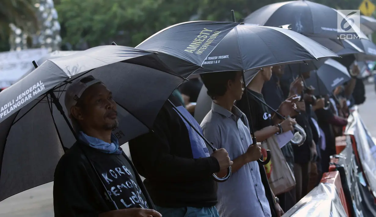Peserta aksi melakukan aksi Kamisan di depan Istana Negara, Jakarta, Kamis (24/1). Mereka meminta pemerintah segera menuntaskan penyelesaian kasus pelanggaran HAM masa lalu dan membentuk pengadilan HAM. (Liputan6.com/Helmi Fithriansyah)