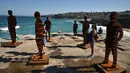 Pengunjung berpose dengan patung berjduul Shifting Horizons karya April Pine saat pameran Sculpture by the Sea di Sydney, Australia, Jumat (19/10). Pameran patung unik ini dibuka secara umum, tanpa memungut biaya sepeser pun. (PETER PARKS/AFP)