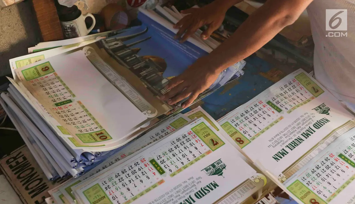 Pekerja merapikan kalender tahun 2019 di kawasan Senen, Jakarta, Jumat (7/12). Menjelang berakhirnya tahun 2018, produksi kalender di kawasan pusat percetakan tersebut meningkat 40 persen. (Liputan6.com/Immanuel Antonius)