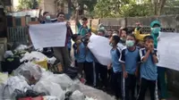 Para guru, siswa dan warga sekitar Kelurahan 14 Ilir Palembang menggelar aksi protes terhadap tumpukan sampah pasar yang tidak pernah diangkut (Dok. Raden untuk Nefri Inge / Liputan6.com)