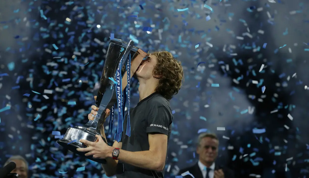 Petenis Jerman, Alexander Zverev mencium trofi setelah mengalahkan Novak Djokovic pada laga puncak ATP Finals 2018 di O2 Arena, London, Senin (19/11). Zverev menjadi petenis termuda yang menjadi juara ATP Finals dalam satu dekade terakhir (AP/Tim Ireland)