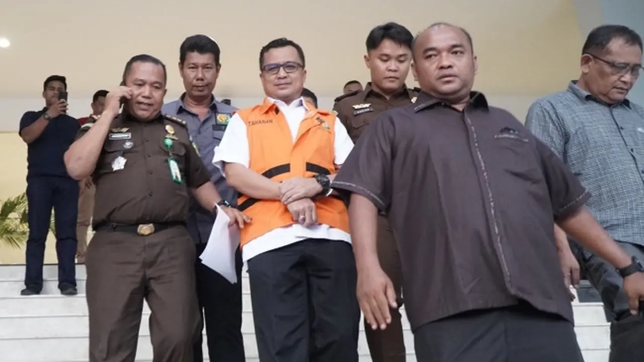 Petugas menggiring Kepala Dinas Pendidikan Riau yang terjerat korupsi perjalanan dinas.