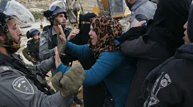 Perempuan Palestina terlibat cekcok dengan polisi Israel saat memprotes pembongkaran rumah di Desa Al-Dirat, dekat kota Hebron, Tepi Barat (16/1/2020). Pembongkaran itu menurut otoritas Israel dilakukan karena rumah dibangun tanpa izin. (AFP/Hazem Bader)