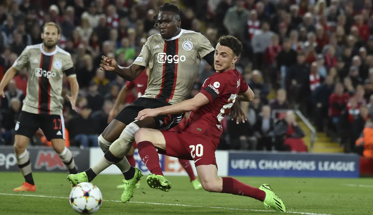 Bek Ajax  Amsterdam Calvin Bassey berebut bola dengan penyerang Liverpool Diogo Jota pada pertandingan kedua Grup A Liga Champions 2022/2023 di Stadion Anfield, Rabu (14/9/2022) dini hari WIB. Liverpool menang susah payah saat menjamu Ajax berkat gol menit akhir bek Joel Matip. (AP Photo/Rui Vieira)