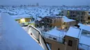Pemandangan di pagi hari saat sejumlah atap rumah tertutup salju tebal di Tokyo, Jepang, Senin (18/1). Akibat banyaknya tumpukan salju yang menyelimuti daerah metropolitan Tokyo, moda transportasi massa pun lumpuh. (AFP PHOTO/KAZUHIRO NOGI)