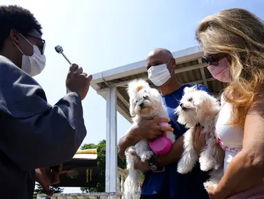 Seorang Fransiskan memberkati anjing peliharaan dalam misa untuk menghormati Santo Fransiskus dari Assisi pada Hari Raya Santo di Brasilia, Brasil, Senin (4/10/2021). Santo Katolik dianggap sebagai pelindung hewan. (AP Photo/Eraldo Peres)